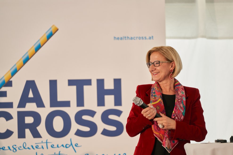 Eine Frau hält ein Mikrofon und lächelt.